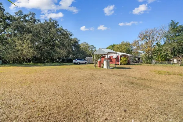 a view of a field with trees in the background