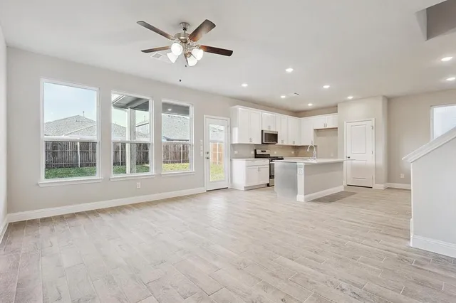 a view of kitchen with granite countertop cabinets and refrigerator