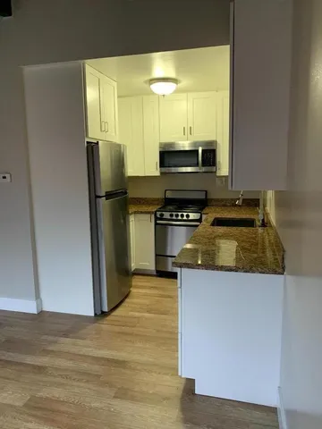 a kitchen with a refrigerator and a stove top oven