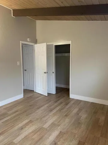 a view of an empty room with wooden floor