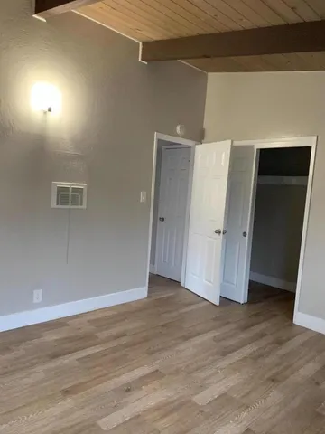 an empty room with wooden floor and closet