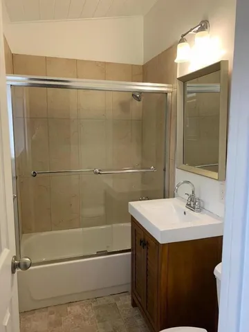 a bathroom with a bathtub a sink and a mirror