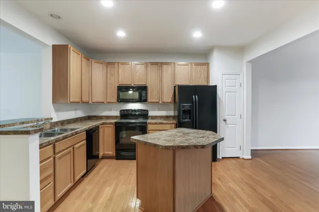 a kitchen with stainless steel appliances granite countertop a sink stove microwave and refrigerator