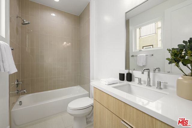 a bathroom with a granite countertop sink a toilet and bathtub