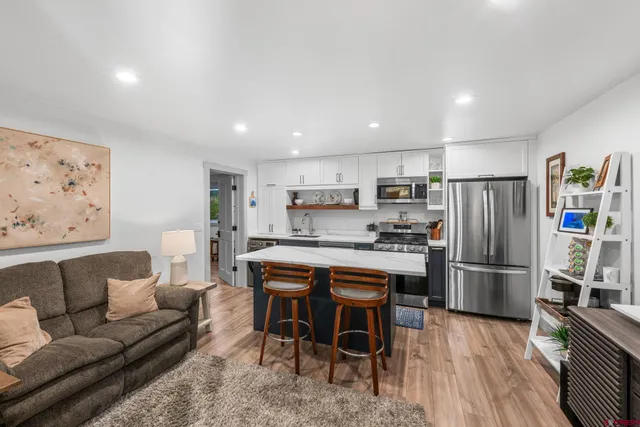a kitchen with stainless steel appliances granite countertop a refrigerator and a stove top oven