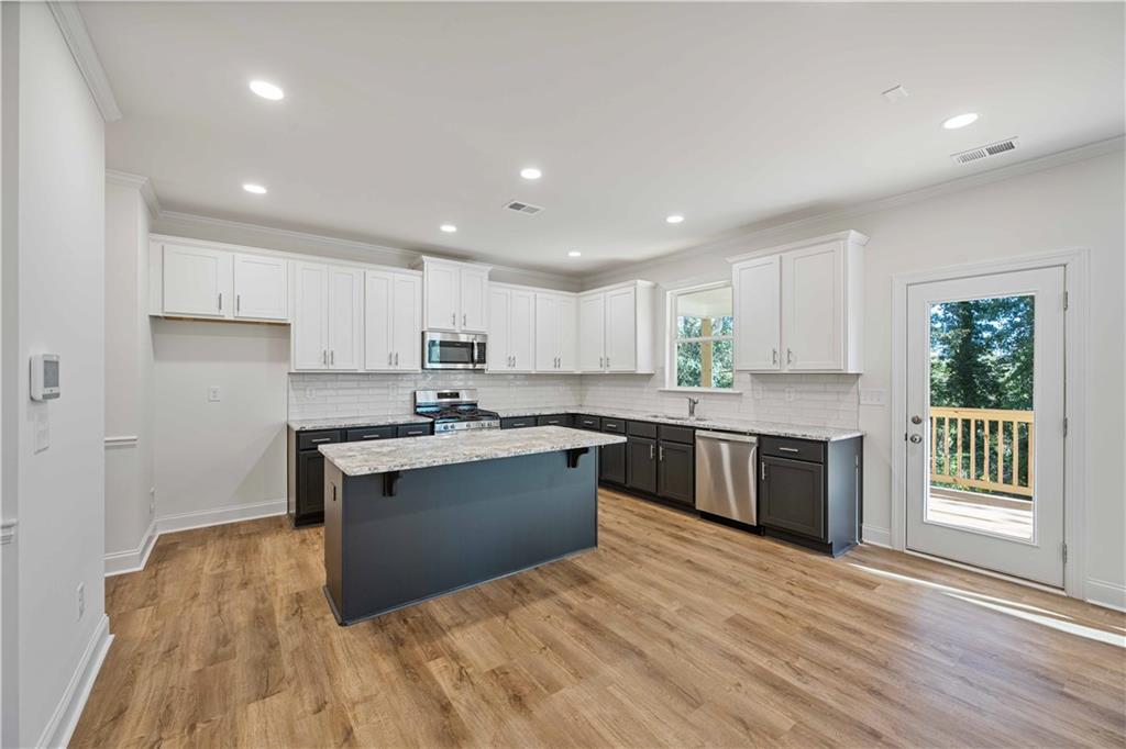 2126 Seavey Drive Decatur, GA 30032 - Photo 13 of 40 a kitchen with a sink wooden floor and stainless steel appliances