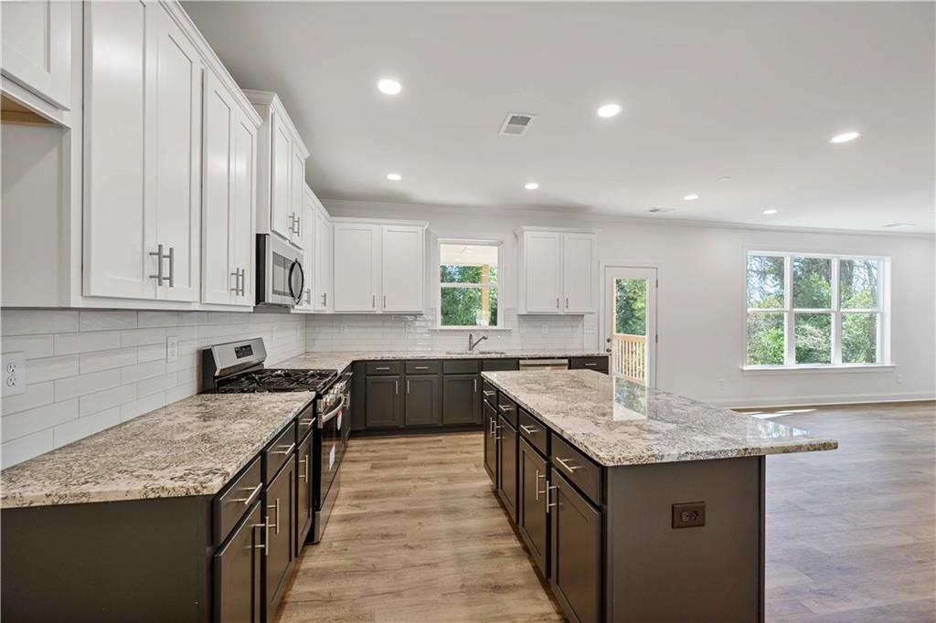 2126 Seavey Drive Decatur, GA 30032 - Photo 15 of 40 a kitchen with granite countertop kitchen island stainless steel appliances a sink stove and cabinets