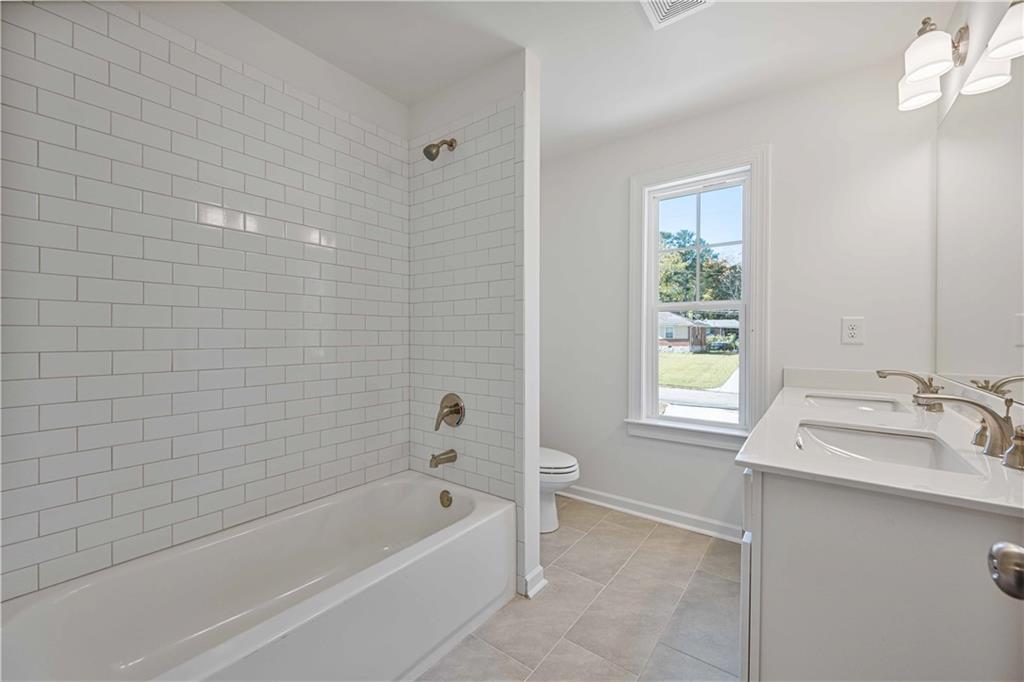 2126 Seavey Drive Decatur, GA 30032 - Photo 32 of 40 a bathroom with a bathtub a sink a vanity and a window
