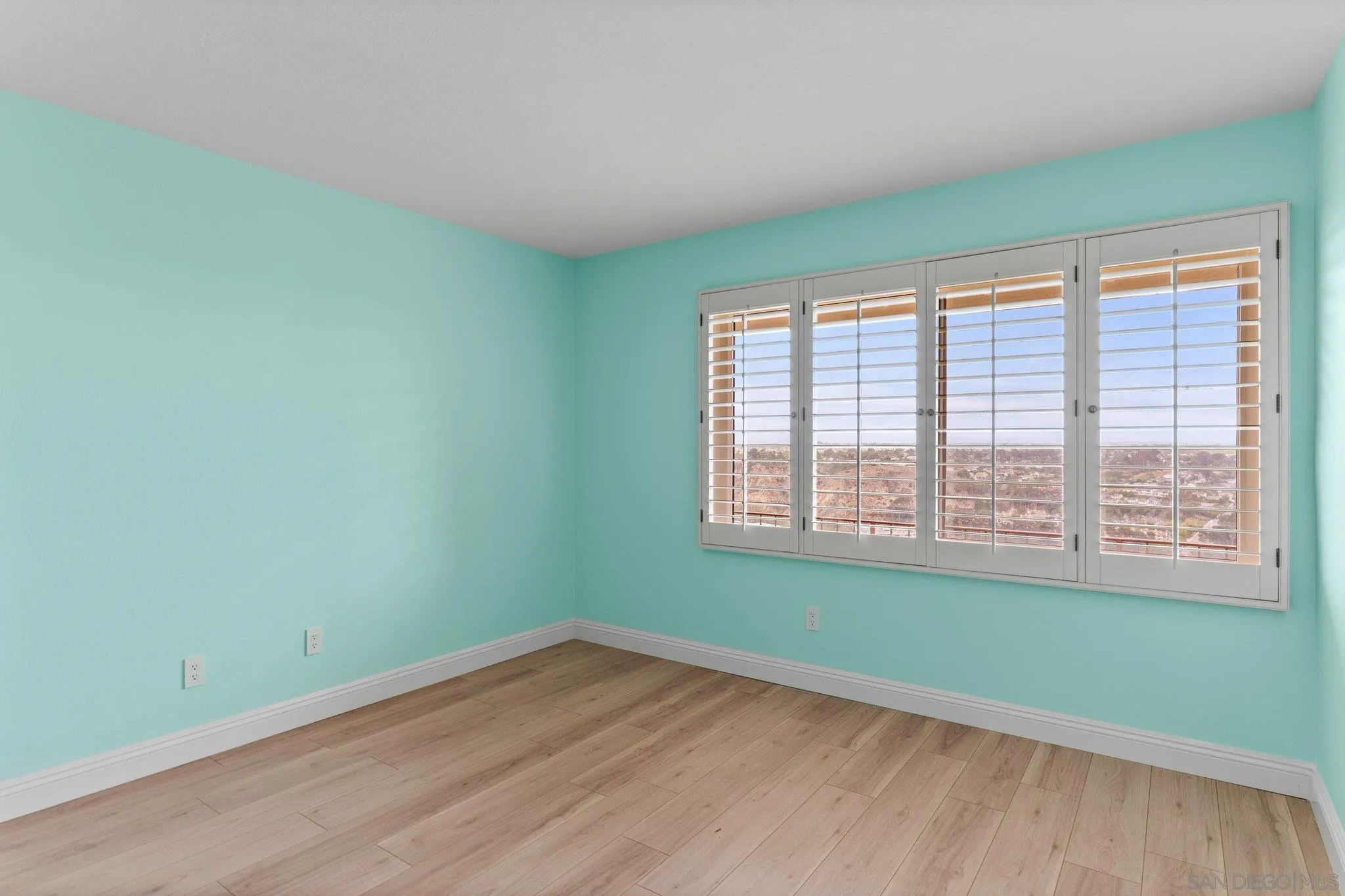5668 Desert View Drive La Jolla, CA 92037 - Photo 16 of 23 a view of an empty room with wooden floor and a window