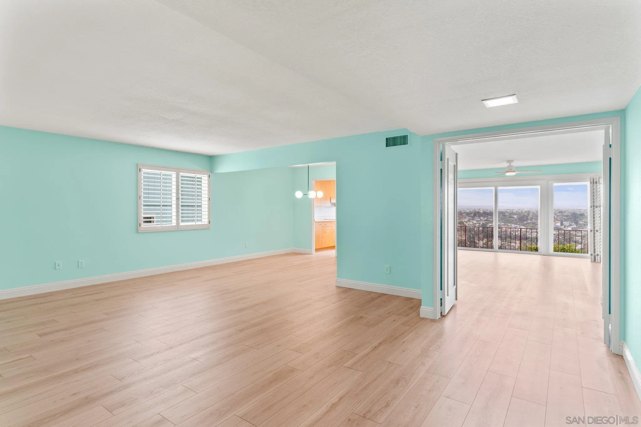 5668 Desert View Drive La Jolla, CA 92037 - Photo 3 of 23 an empty room with wooden floor and windows