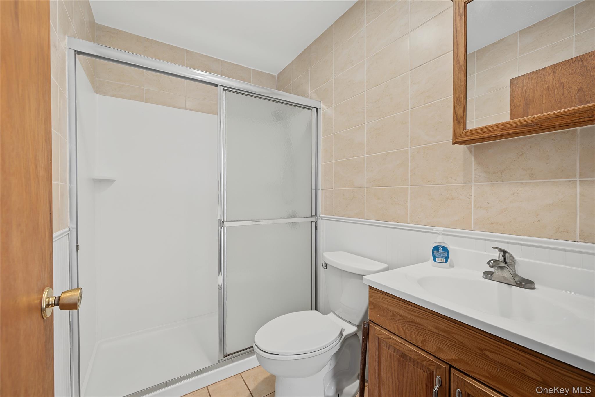 318 Cornwall Hill Road Patterson, NY 12563 - Photo 10 of 38 Bathroom featuring a shower with sliding glass doors, a white toilet, and a wood-finish vanity with an integrated sink