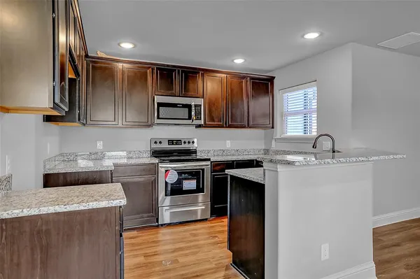 a kitchen with stainless steel appliances granite countertop a stove top oven a sink and dishwasher
