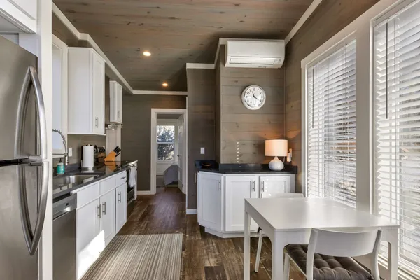 a kitchen with stainless steel appliances granite countertop a stove a sink and white cabinets