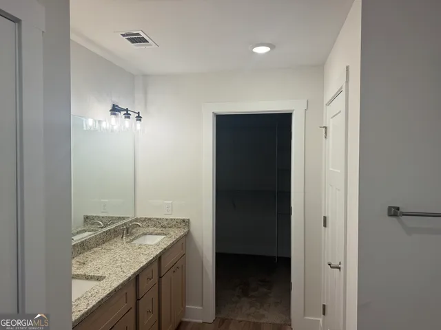 a bathroom with a granite countertop sink and a mirror