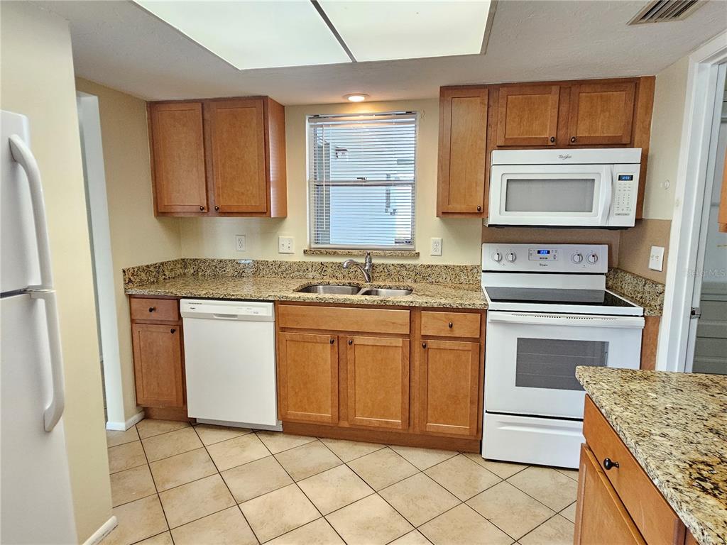 105 Base Avenue East Venice, FL 34285 - Photo 8 of 31 a kitchen with granite countertop cabinets and steel stainless steel appliances