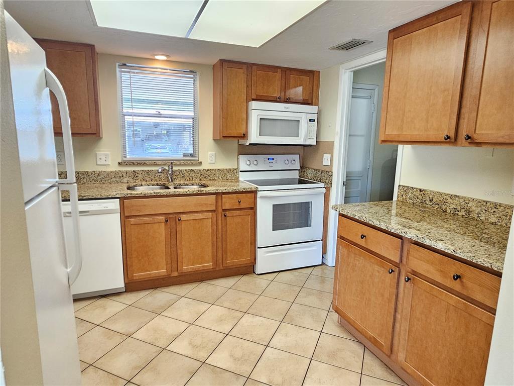 105 Base Avenue East Venice, FL 34285 - Photo 9 of 31 a kitchen with stainless steel appliances granite countertop a sink stove and refrigerator