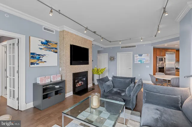 a living room with furniture a flat screen tv and a fireplace