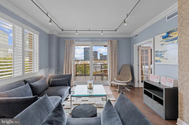 a living room with furniture a flat screen tv and large windows