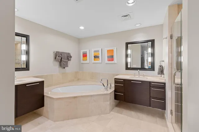 a spacious bathroom with a tub sink and mirror