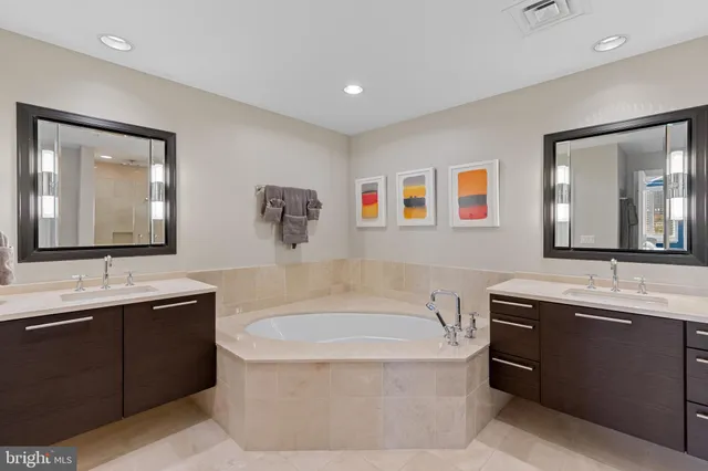 a bathroom with a tub a sink and mirror
