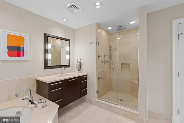 a bathroom with a tub sink shower and mirror