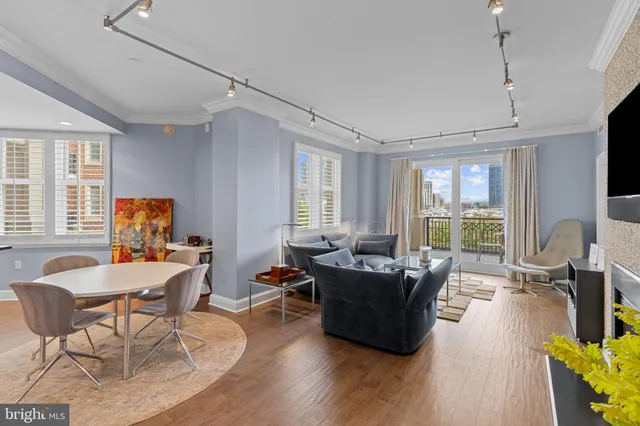 a living room with furniture floor to ceiling window and wooden floor