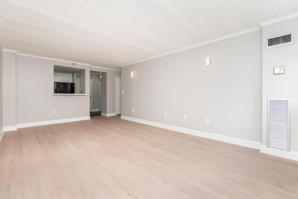 1933 Commonwealth Avenue, Unit 108 Boston, MA 02135 - Photo 11 of 27 a view of an empty room with wooden floor and a window