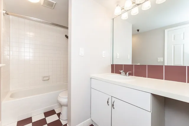 a bathroom with a sink a toilet a mirror and shower