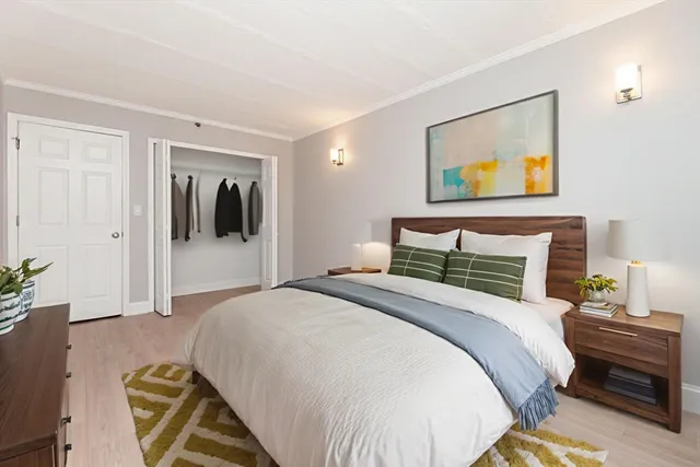 a bedroom with a bed and a painting on the wall