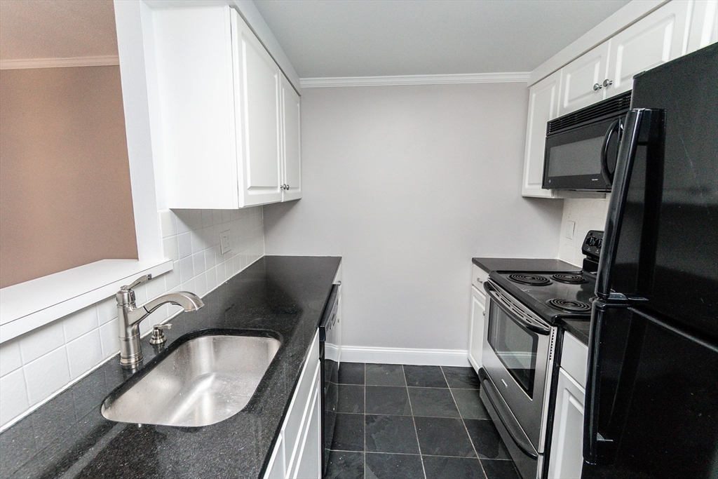 1933 Commonwealth Avenue, Unit 108 Boston, MA 02135 - Photo 8 of 27 a kitchen with a sink stove and refrigerator