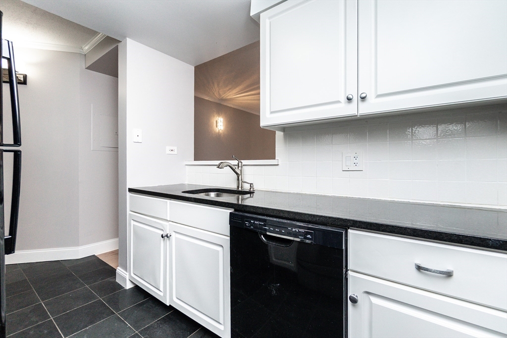 1933 Commonwealth Avenue, Unit 108 Boston, MA 02135 - Photo 9 of 27 a kitchen with granite countertop white cabinets and white appliances