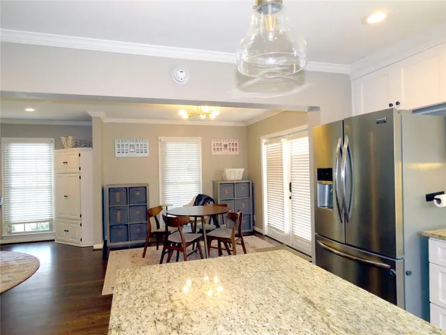 a living room with stainless steel appliances furniture a fireplace a flat screen tv and view kitchen