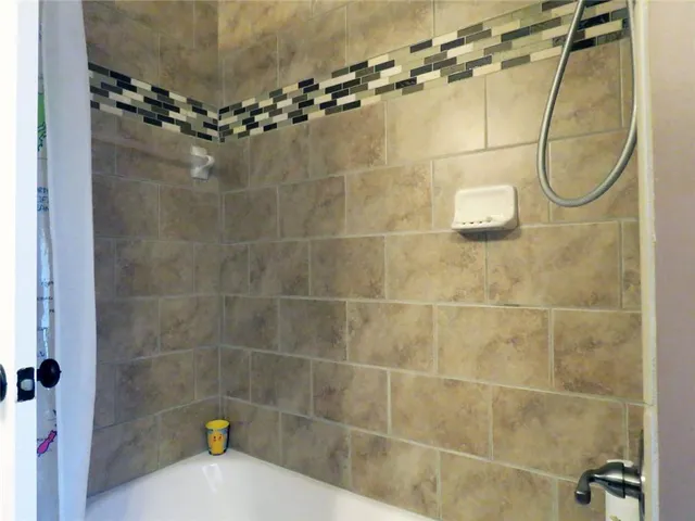 a bathroom with a granite countertop sink mirror and shower