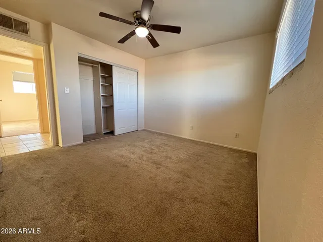 an empty room with a ceiling fan and a window