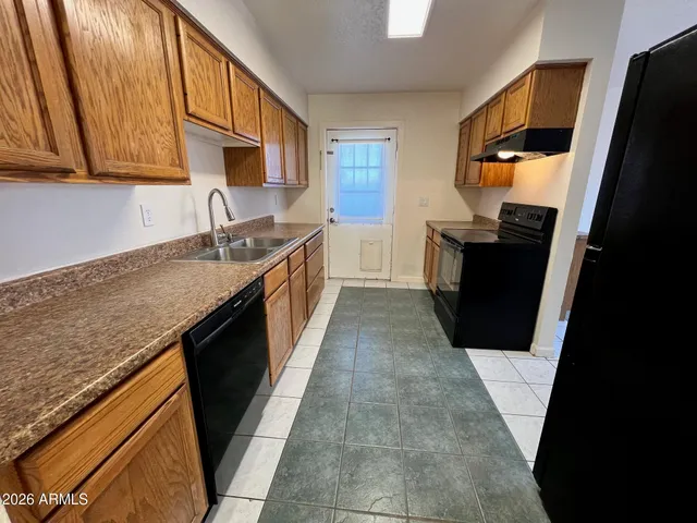 a kitchen with granite countertop a sink stove and cabinets