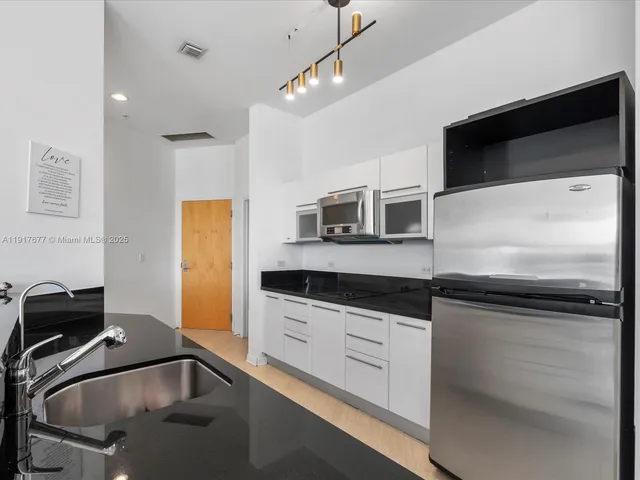 a kitchen with stainless steel appliances granite countertop a sink and a microwave