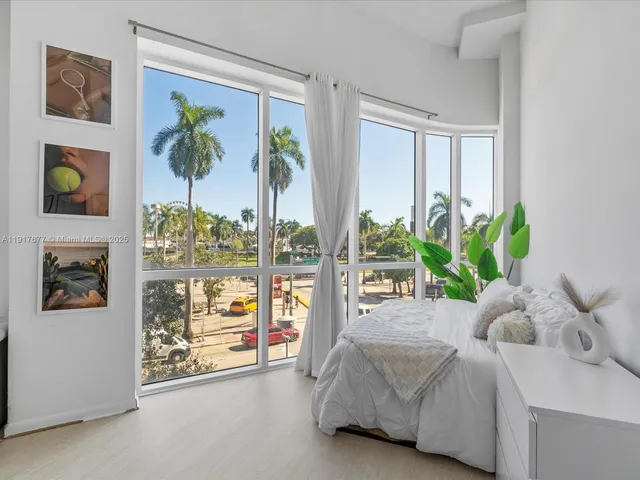 a bedroom with furniture and large window