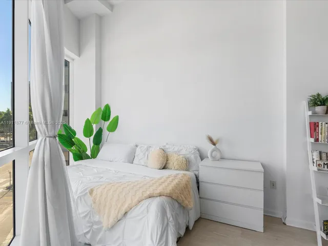 a bedroom with a bed mirror and window