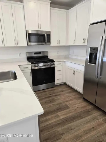 a kitchen with granite countertop a sink and stainless steel appliances