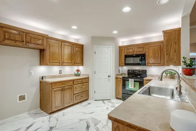a kitchen with a sink stove and wooden cabinets
