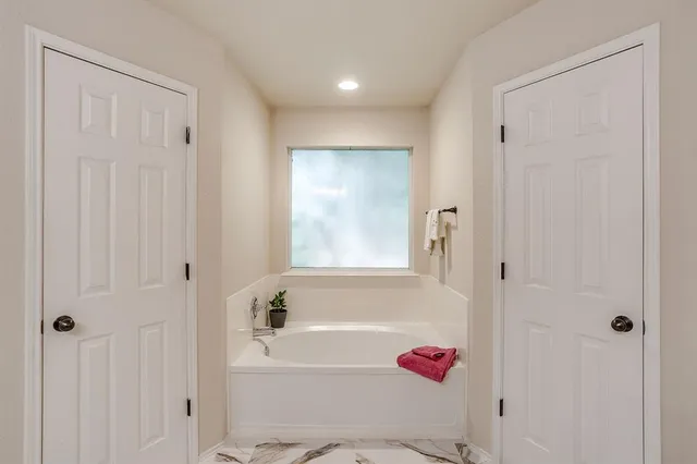 a bathroom with a tub shower and a sink