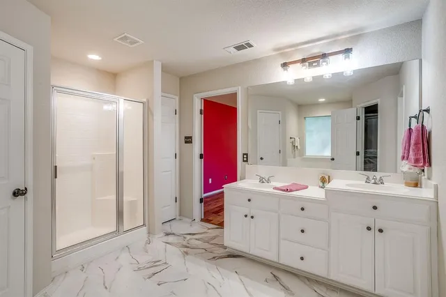 a bathroom with a sink mirror and shower