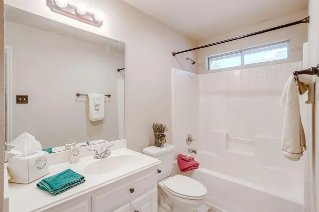 a bathroom with a sink vanity mirror and toilet