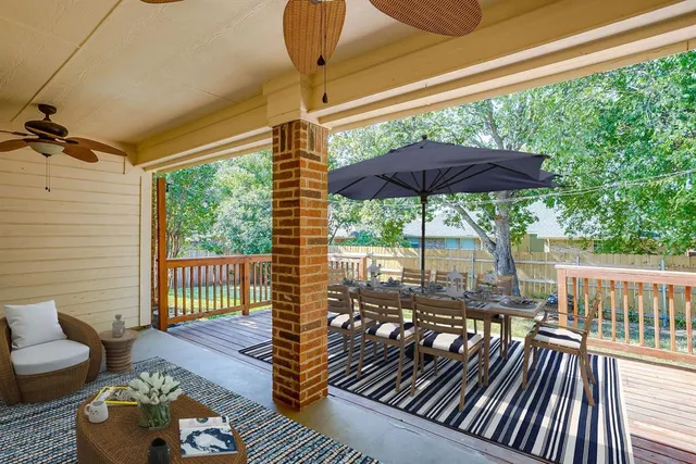a view of a patio with a table chairs and a barbeque