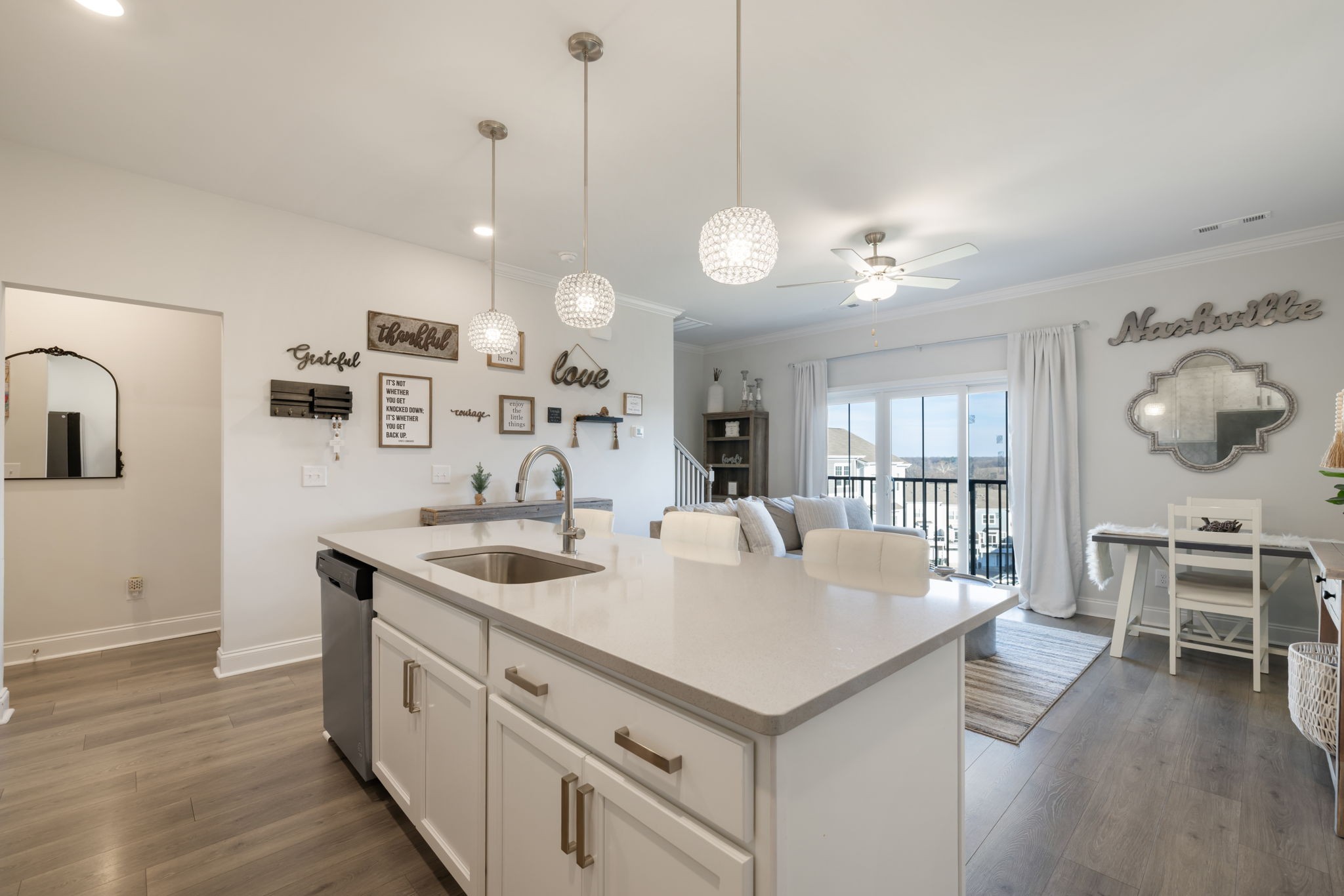 4018 Orsman Lane Antioch, TN 37013 - Photo 19 of 75 a large white kitchen with a large island oven a stove a sink a dining table and chairs with wooden floor