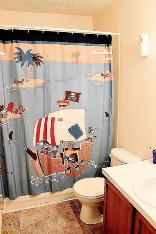 a bathroom with a sink toilet and shower