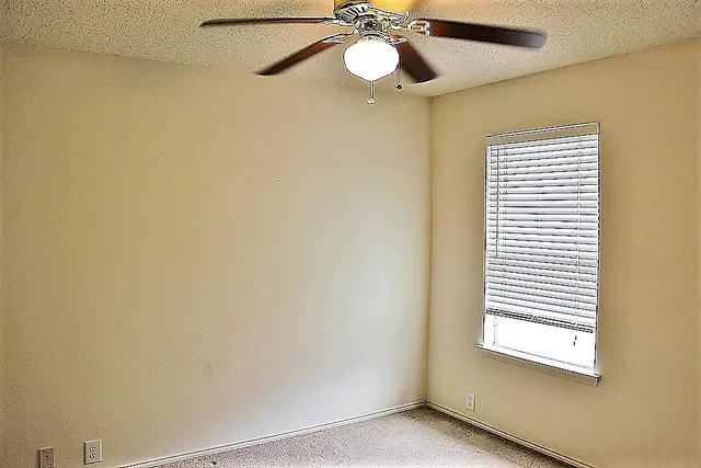 a view of a room with a window and a ceiling fan