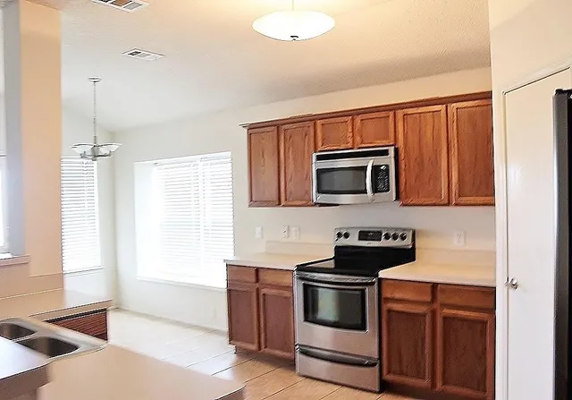 a kitchen with stainless steel appliances a stove a microwave and a sink
