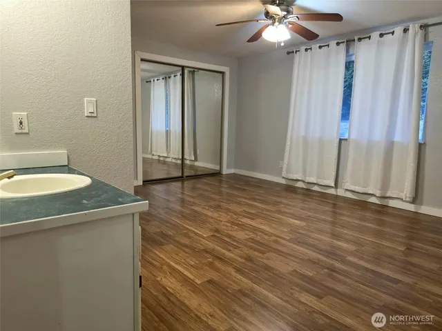 a view of a kitchen with a sink and dishwasher with wooden floor