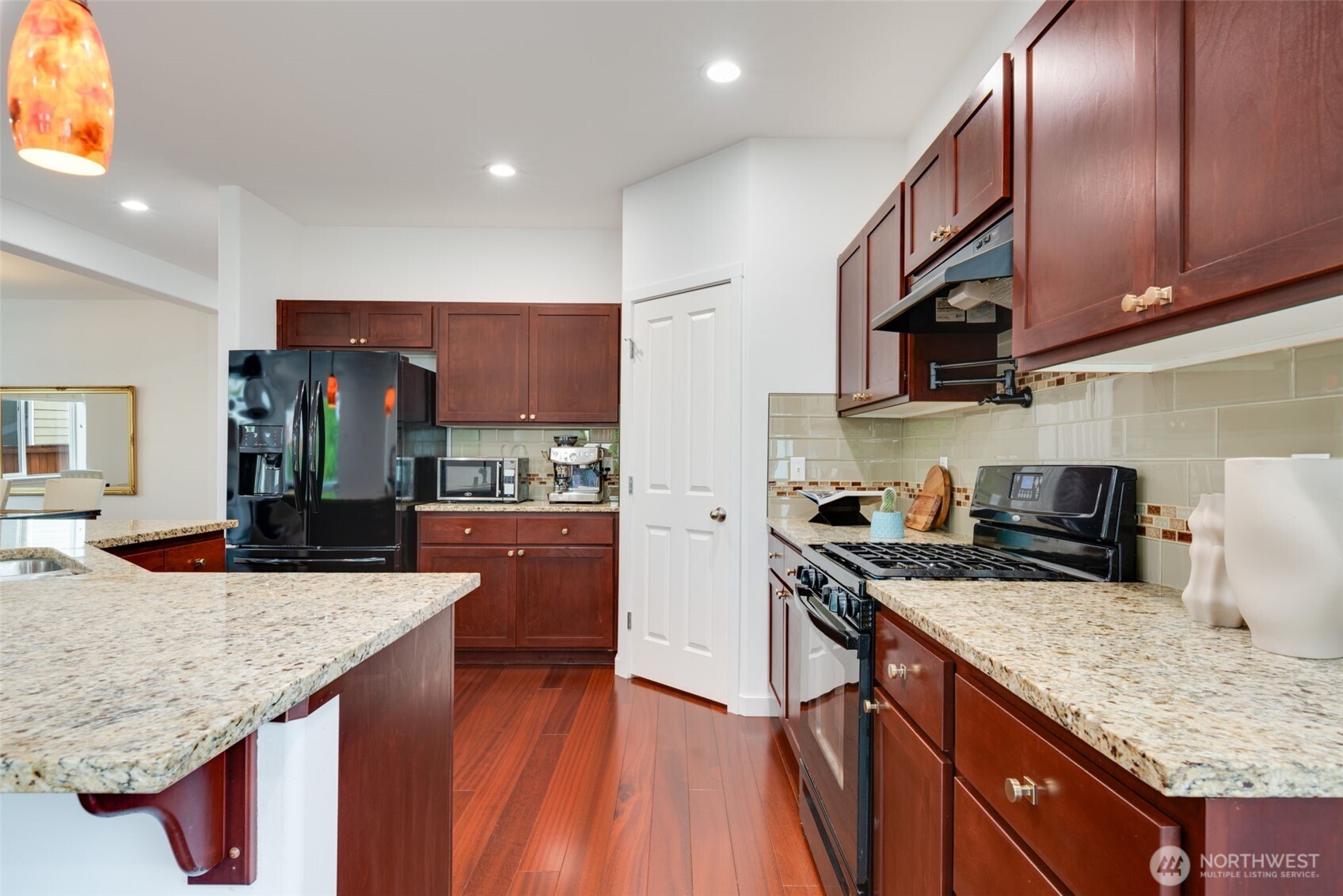 17026 Southeast 263rd Street Covington, WA 98042 - Photo 11 of 40 a kitchen with granite countertop stainless steel appliances and wooden cabinets